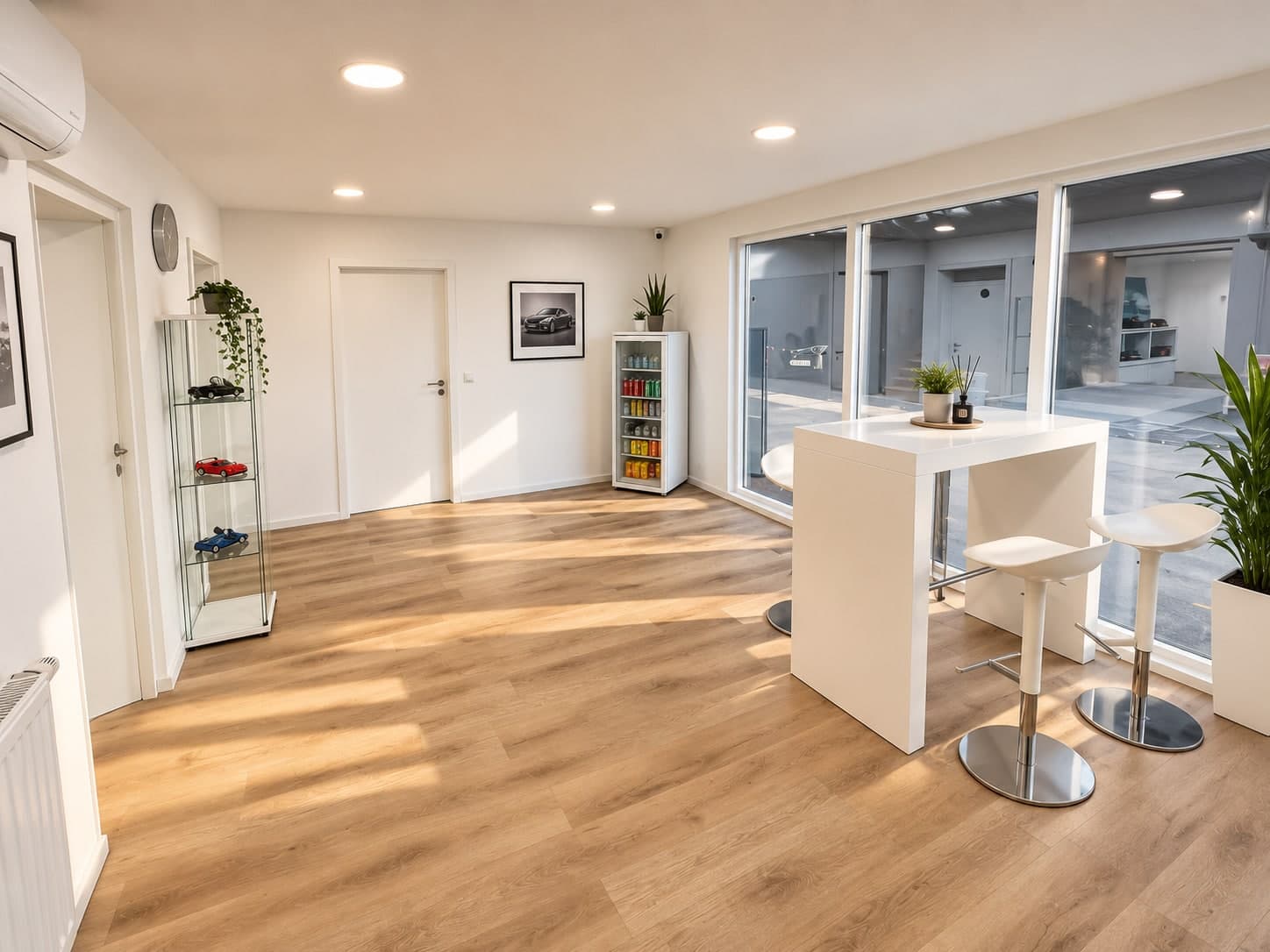 Empfangsbereich von Auto Aras mit Sitzecke, Modellauto-Vitrine und Blick auf den Hof